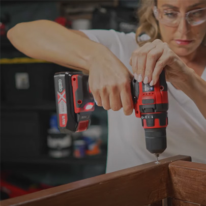 A woman drills a hole with a cordless screwdriver